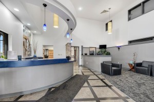 Contemporary dental office reception area with curved front desk and modern lighting