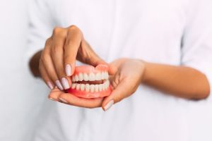 dentures held in woman's hands